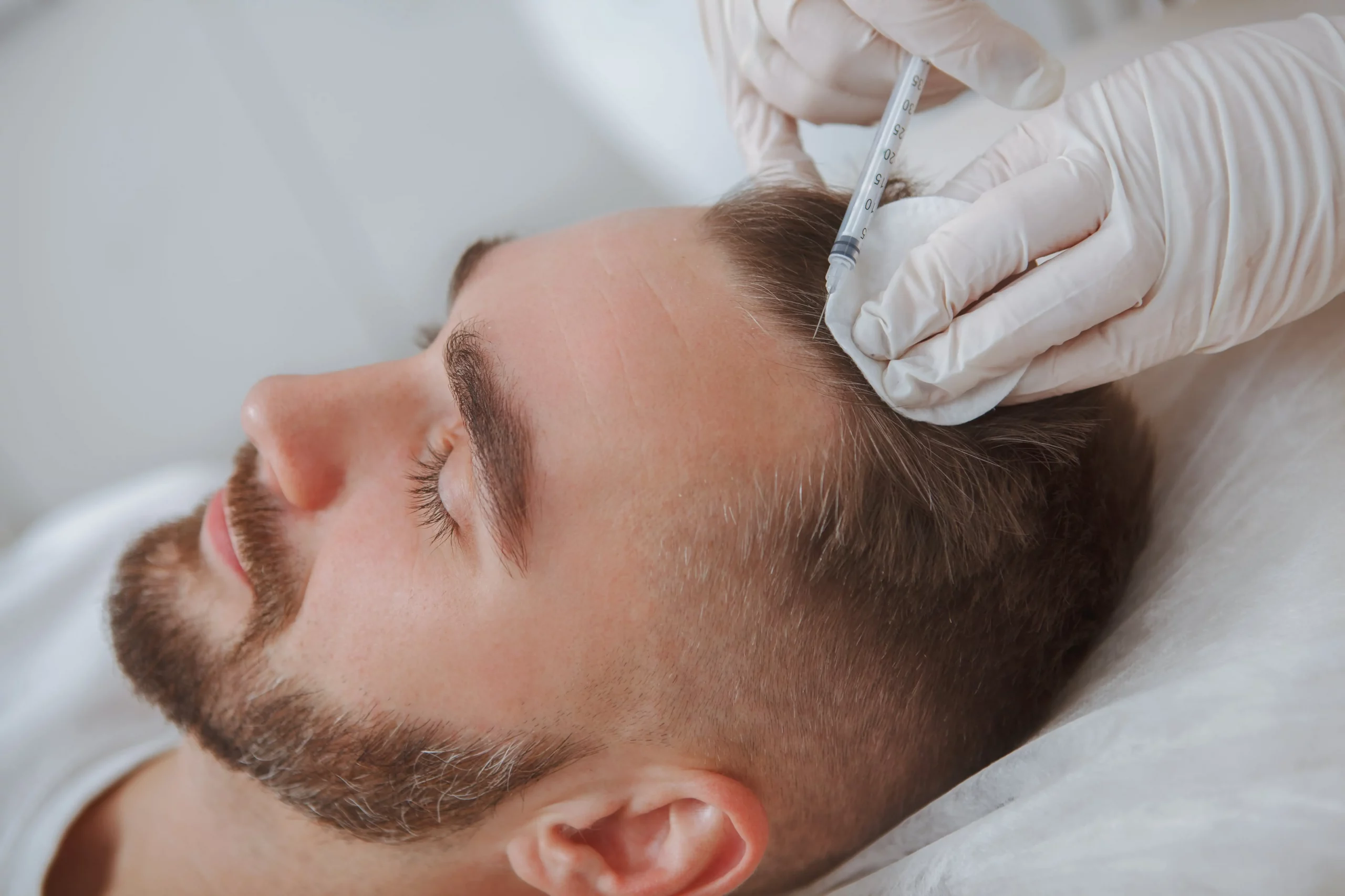Man receiving cosmetic injection in forehead for Botox or filler treatment