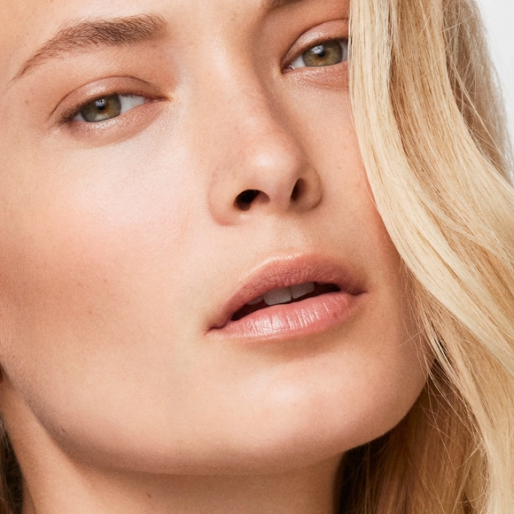 Close-up portrait of woman with clear skin and hands near face for cosmetic injectables